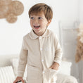 Afbeelding laden in Galerijviewer, Beige pyjama Lou met wit biesje – zacht en stijlvol babypakje, perfect om te laten personaliseren.