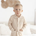 Afbeelding laden in Galerijviewer, Detailfoto van pyjama Lou in beige met fijne witte bies – hoogwaardige afwerking uit het atelier van Little Steps