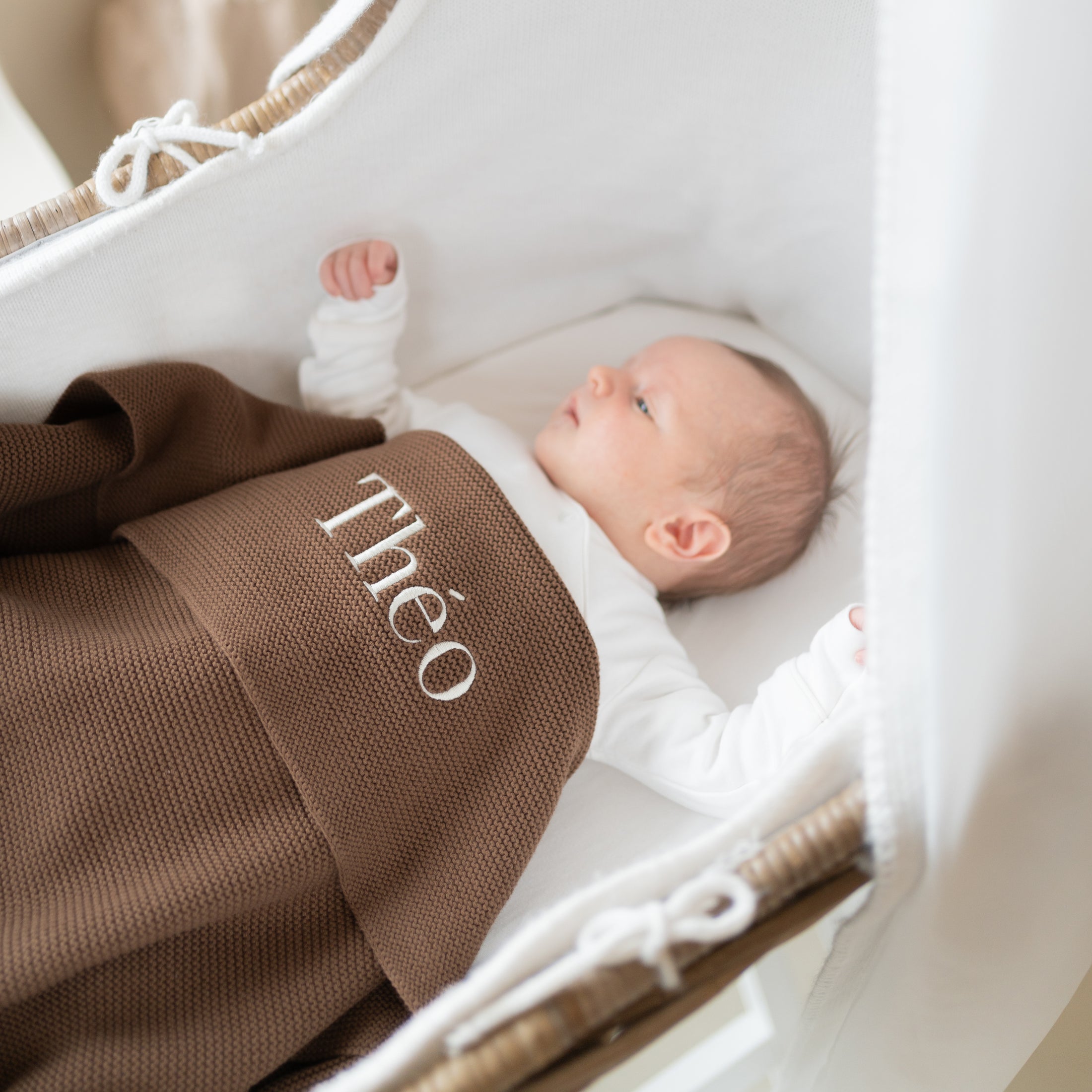 baby onder gepersonaliseerd babydeken met naam in wieg