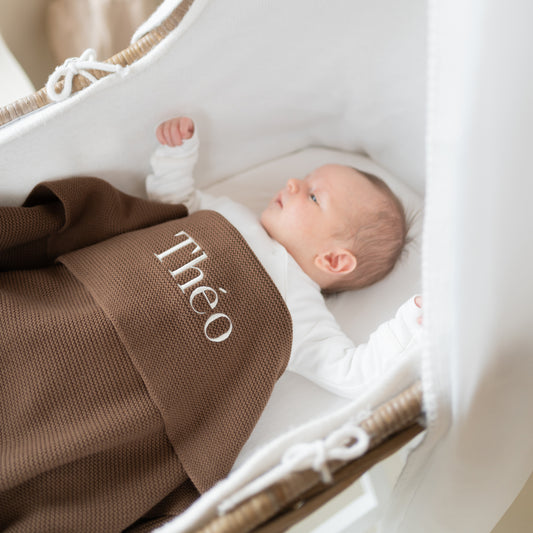 baby onder gepersonaliseerd babydeken met naam in wieg