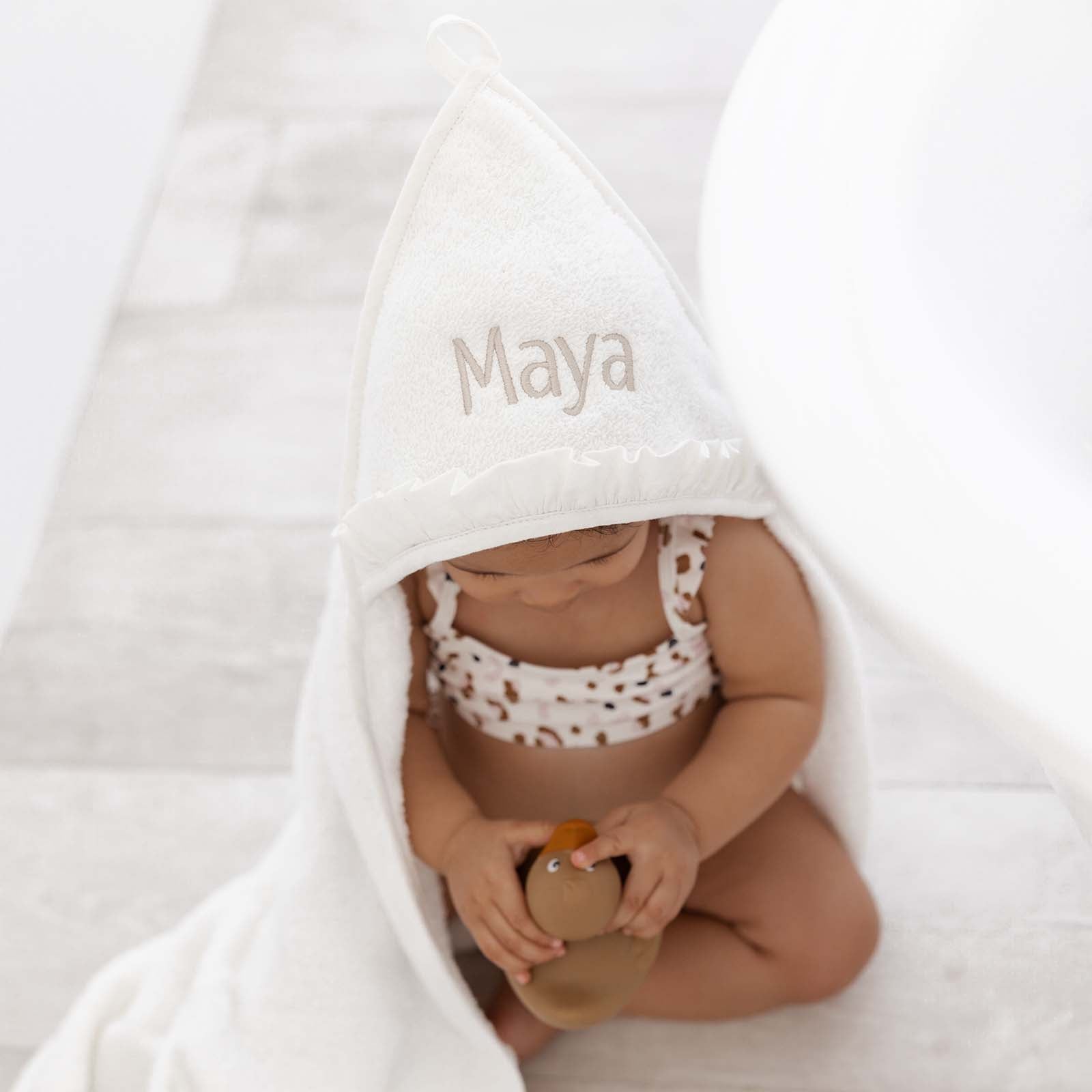 Badcape met ruffeltje en naam – stijlvol gepersonaliseerd kraamcadeau, handgeborduurd in België