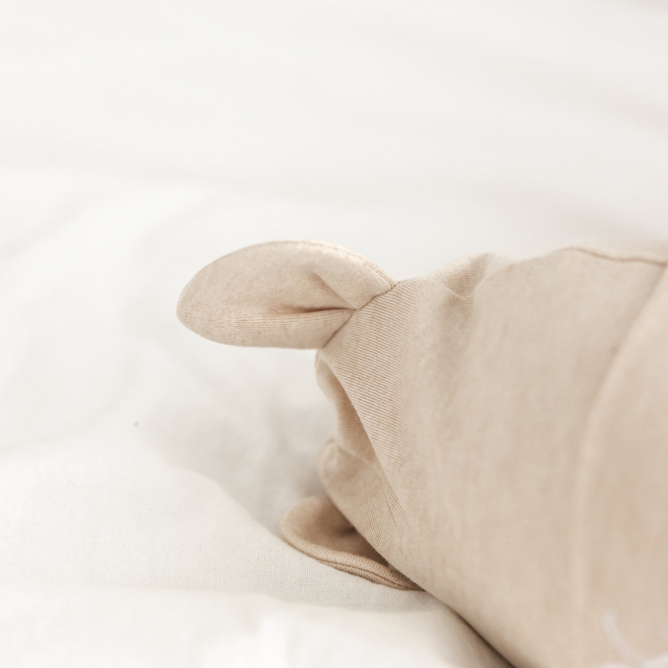 Close-up van babymutsje met berenoortjes – schattig detail op zacht gepersonaliseerd baby mutsje in neutrale tinten