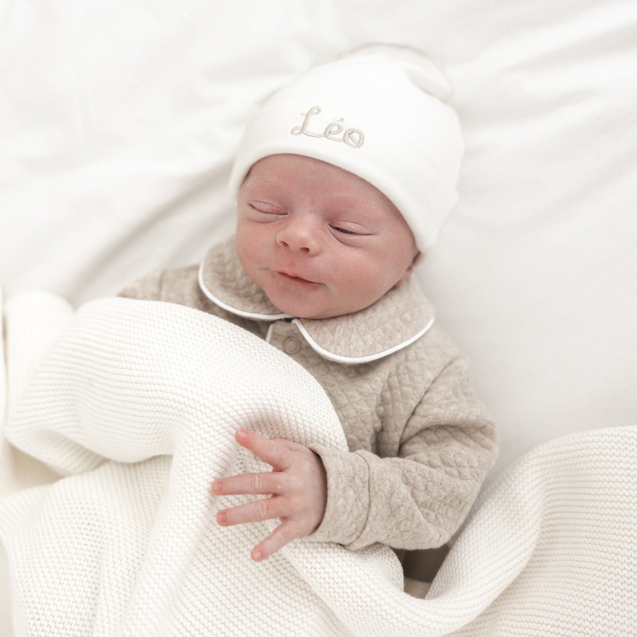Detail van babymutsje – fijn geborduurde naam in zachte tint, subtiele afwerking en rekbare stof voor newborn baby’s