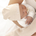 Afbeelding laden in Galerijviewer, Detail van stof en pasvorm van babymutsje – zachte, rekbare stof die comfortabel aansluit rond het babyhoofdje
