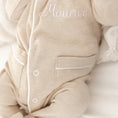 Afbeelding laden in Galerijviewer, Detail van Kruippakje Lou – witte bies en fijn geborduurde naam, luxueuze afwerking voor babykleding
