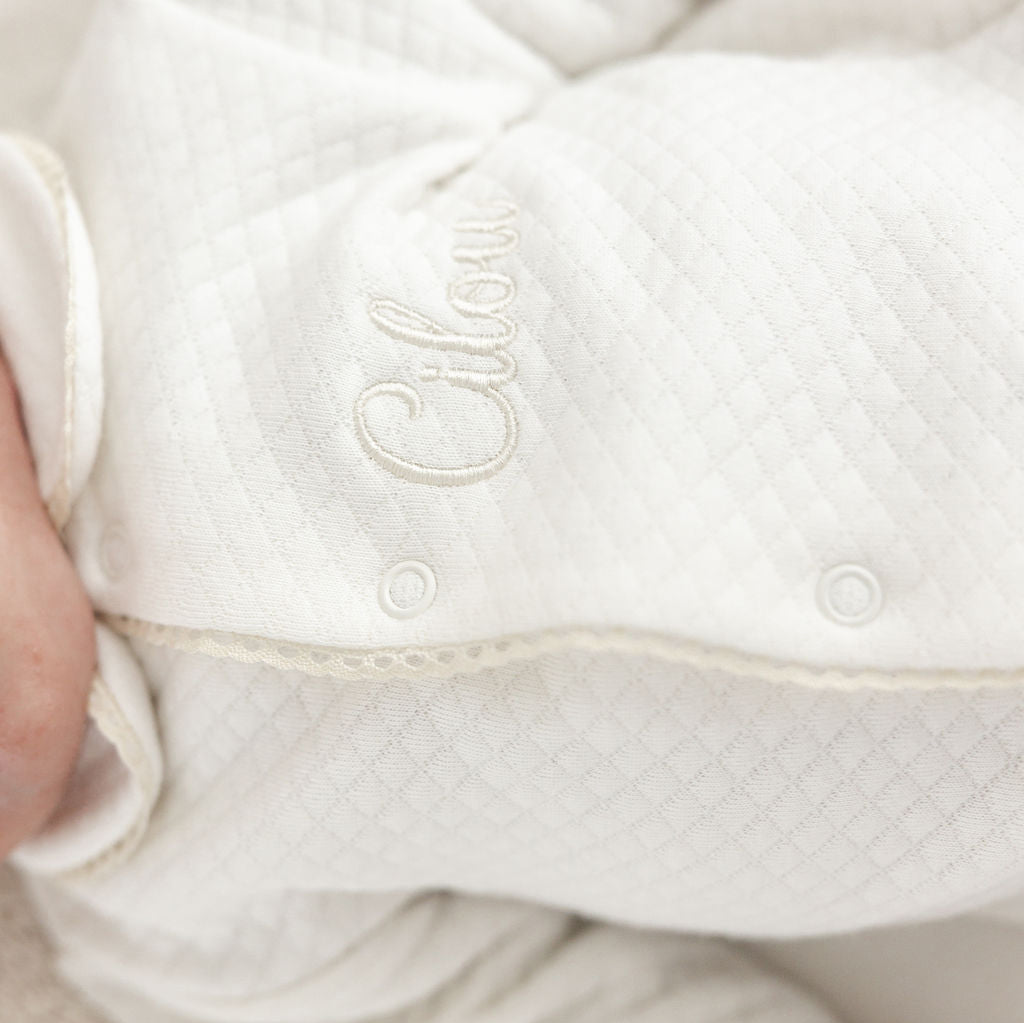 Kruippakje Lucie met naam geborduurd – subtiele borduring in kleur van het biesje, gepersonaliseerd babykruippakje