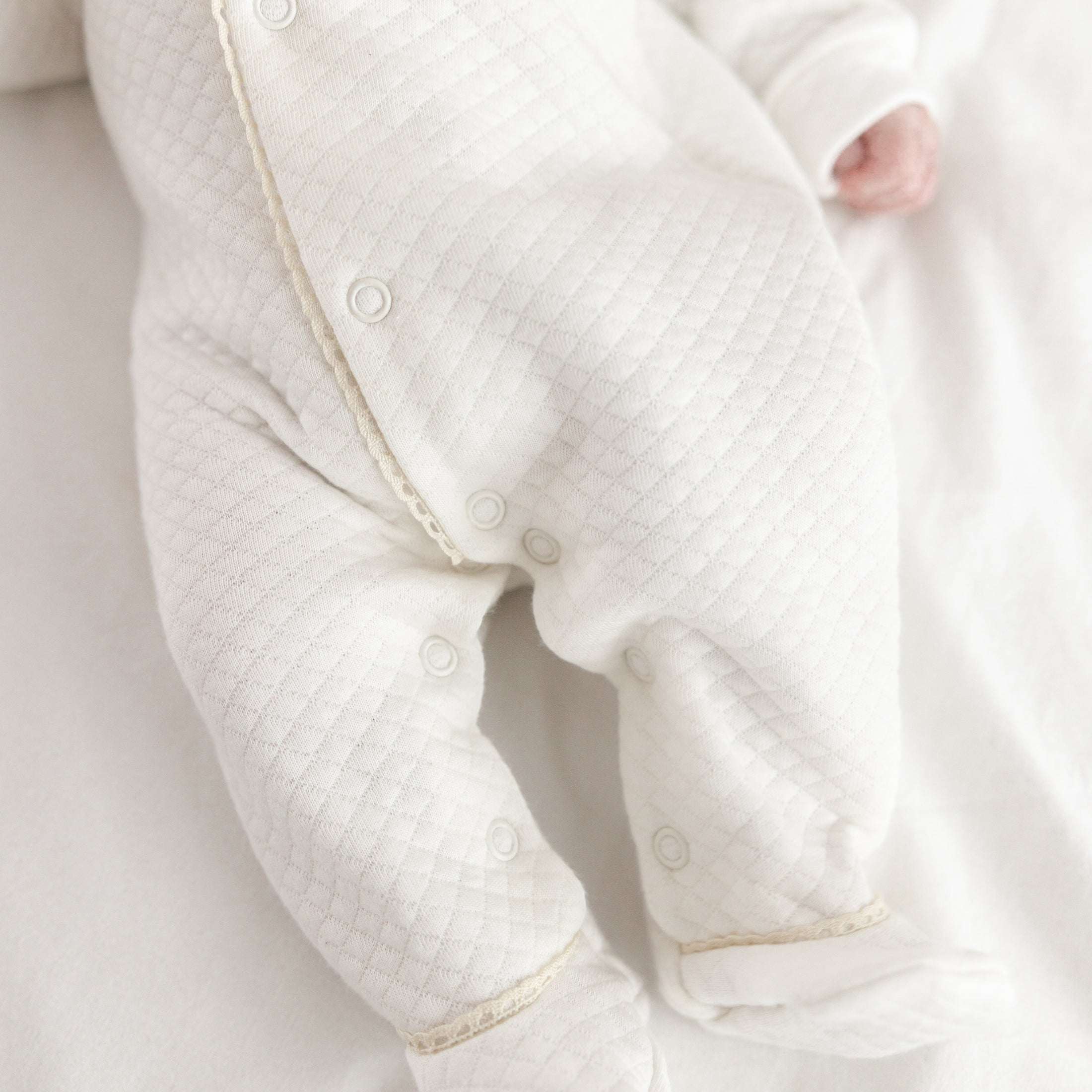 Kruippakje Lucie met naam geborduurd – subtiele borduring in kleur van het biesje, gepersonaliseerd babykruippakje